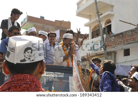 AMETHI - APRIL 20:  Supporters with AAP cap walking in front of the jeep during a road show in support of Amethi candidate Dr. Kumar Viswas on April 20, 2014 in Amethi ,India.