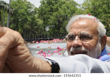 NEW DELHI-MAY 17: Indian Prime Minister Narendra Modi  waiving towards the crowd during a roadshow  after wining the Indian National election on May 17, 2014 in New Delhi , India.