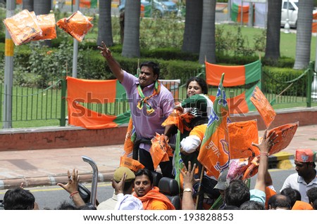 NEW DELHI-MAY 17:  BJP supporters distributing NAMO caps during a rally after wining the Indian National election on May 17, 2014 in New Delhi , India.
