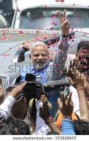 NEW DELHI-MAY 17: Indian Prime Minister Narendra Modi showing victory sign towards the crowd during a roadshow after wining the Indian National election on May 17, 2014 in New Delhi , India.