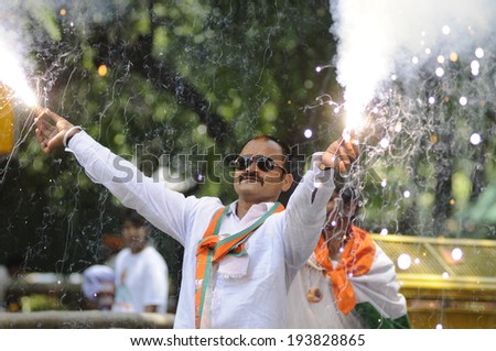 NEW DELHI-MAY 16:   A BJP supporter  lighting a firecracker  after BJP party  won the Indian National election on May 16, 2014 in New Delhi , India.