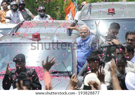 NEW DELHI-MAY 17: Indian Prime Minister Narendra Modi waiving towards the crowd and waiting media  during a roadshow  after wining the Indian National election on May 17, 2014 in New Delhi , India.