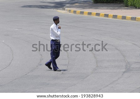 NEW DELHI-MAY 17: A police man walking on an emptied street  before Indian Prime Minister Narendra Modi\'s arrival  after wining the Indian National election on May 17, 2014 in New Delhi , India.