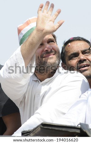 VARANASI - MAY 10: Rahul Gandhi waiving towards the crowd  sitting on the roof during a road show  to support local Congress candidate Mr. Ajay Rai on May 10, 2014 in Varanasi , India.