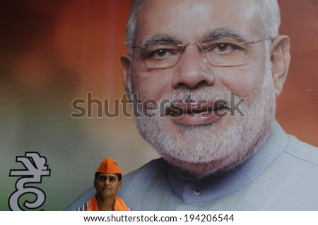 NEW DELHI-MAY 16:   A BJP supporter  standing in front of a Narendra Modi image at the party headquarter after BJP  won the Indian National election on May 16, 2014 in New Delhi , India.