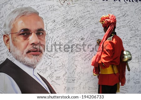 NEW DELHI-MAY 16:  A musician  writing a message on a message board to write best wishes for Mr. Modi after wining the Indian National election on May 16, 2014 in New Delhi , India.