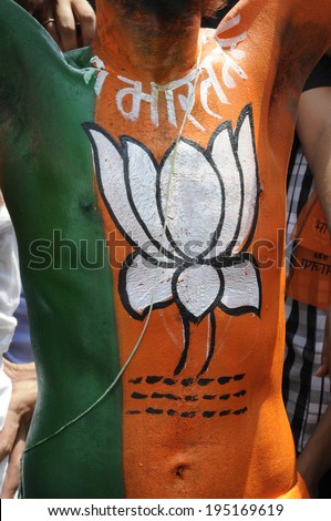 VARANASI - MAY 8:  A BJP supporter with a symbol of BJP - a lotus painted on his upper body during a  political rally on May 8, 2014 in Varanasi , India.