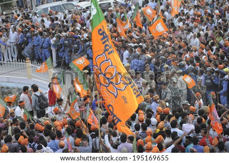 VARANASI - MAY 8:  Supporters waiving BJP party flags during a roadshow in front of BHU university on May 8, 2014 in Varanasi , India.