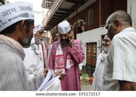 VARANASI - MAY 8: Yogendra Yadav an AAP leader talking on phone on an early morning door to door campaign on the streets  on May 8, 2014 in Varanasi , India.
