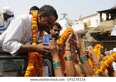 VARANASI - MAY  4 : Arvind kejriwal  putting forward his neck to allow his supporters to garland him during a political meeting on May 4 , 2014 in Varanasi , India.