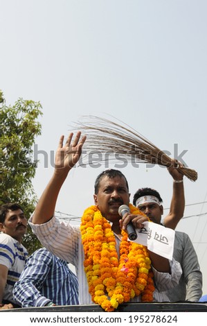 VARANASI - MAY  4 : Arvind kejriwal  giving spech while on of his follower waives a broom on the back  during a political meeting on May 4 , 2014 in Varanasi , India.
