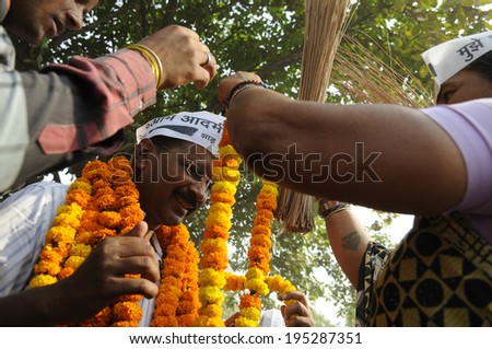 VARANASI - MAY  4 : Supporters with broom - which is an election symbol of AAP garlanding Arvind kejriwal  during a road show on May 4 , 2014 in Varanasi , India.