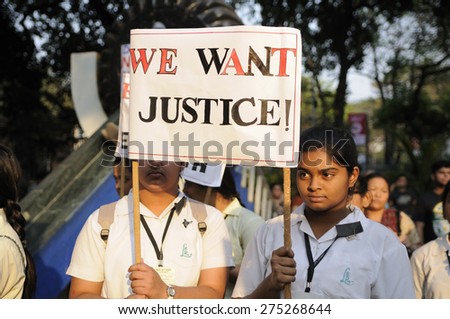 KOLKATA -MARCH 16 :Girls from a local school holding signs which asks for justice during a candle light vigil to protest gang rape of an elderly nun on March 16, 2015, at Allen Park in Kolkata,India.