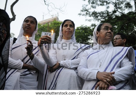 KOLKATA - MARCH 16 : Three Christian Nuns saying prayers with burning candles during a candle light vigil to protest gang rape of an elderly nun on March 16, 2015 at Allen Park in Kolkata, India.