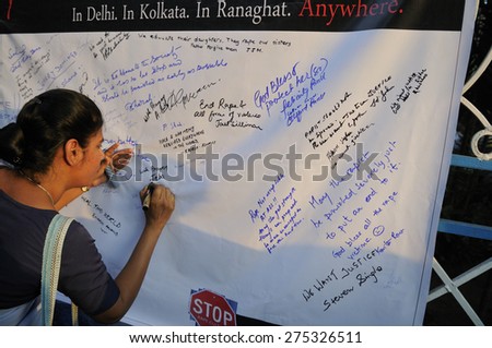 KOLKATA - MARCH 16 :A woman writing solidarity messages on a message board  during a candle light vigil to protest gang rape of an elderly nun on March 16, 2015 at Allen Park in Kolkata, India.