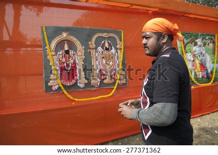 KOLKATA -DECEMBER 20:A man taking cell phone pictures of statue of Indian Gods and Goddess during the Golden Jubilee celebration of VHP on December 20, 2014 in Kolkata, India.