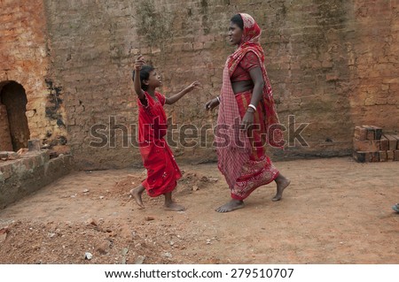KOLKATA-OCTOBER 26: A girl child walking towards her mother inside a brick factory where her family work and stay for minimum wage and unhealthy living conditions on October 26, 2014 in Kolkata,India.