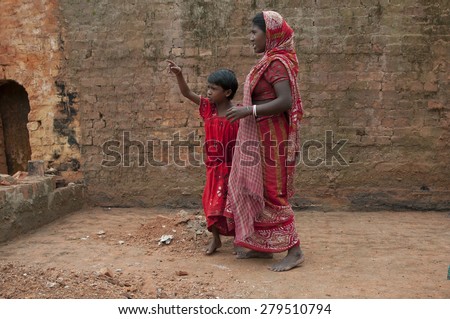 KOLKATA-OCTOBER 26: A girl child talking to her mother inside a brick factory where they work and stay for minimum wage and unhealthy living conditions on October 26, 2014 in Kolkata,India.