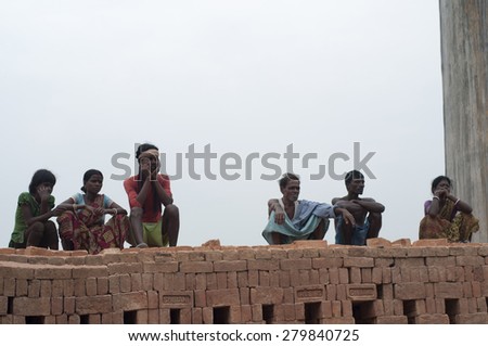 KOLKATA - OCTOBER 26 : Group of brick factory workers sitting on stacks of bricks -brick manufacturing industry in India is a 3 billion dollar industry on October 26, 2014 in Kolkata , India.