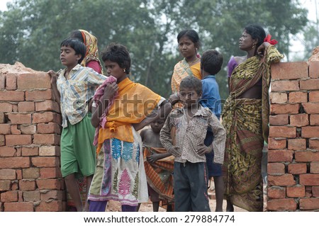 KOLKATA -OCTOBER 26 :Women and kids standing inside a brick factory where they work in tough conditions although India is the the second largest brick industry on October 26, 2014 in Kolkata , India.
