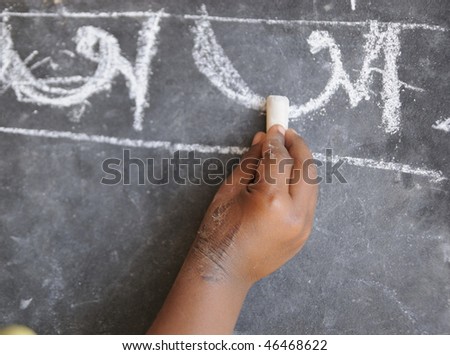 A poor kid in India learning to write alphabets.