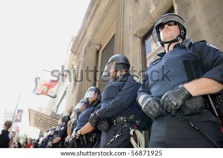 TORONTO-JUNE 25:  Toronto Police officers in riot gear protecting  a financial building during the G20 Protest on June 25, 2010 in Toronto, Canada.