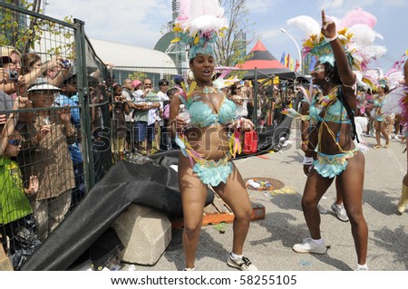 TORONTO - JULY 31:  Participants dancing while crowds watch from behind the fences, during the 43rd Annual Caribana Parade   on July 31, 2010 in Toronto.