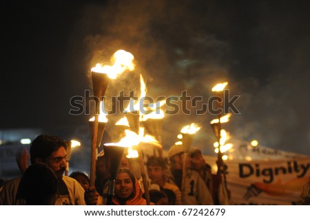 BHOPAL- DECEMBER 2: People carry torches and banners  during the torch rally organized to mark the 26th year of Bhopal gas disaster, in Bhopal - India on December 2, 2010.