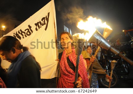 BHOPAL- DECEMBER 2: A woman being given fire for her torch  during the torch rally organized to mark the 26th year of Bhopal gas disaster, in Bhopal - India on December 2, 2010.
