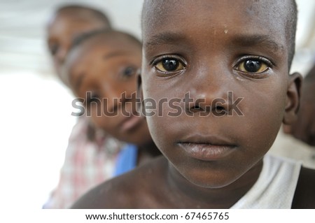 PORT-AU-PRINCE - AUGUST 22: unidentified Haitian kids looking over the shoulder of  each other during a food distribution camp in Port-Au-Prince, Haiti on August 22, 2010.