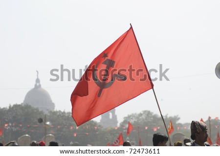 KOLKATA- FEBRUARY 13: A cadre walks around with a flag held high,  during a political rally  in Kolkata, India on February 13, 2011.