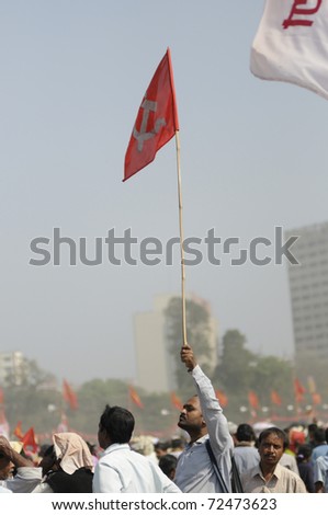 KOLKATA- FEBRUARY 13: A man waiving a communist emblem ed flag to somebody in the crowd, during a political rally  in Kolkata, India on February 13, 2011.