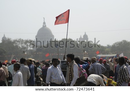 KOLKATA- FEBRUARY 13:  Followers listening to the rally while holding their flags high, during a political rally  in Kolkata, India on February 13, 2011.