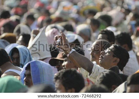KOLKATA- FEBRUARY 13:    An unidentified supporter takes picture through his mobile phone,during a political rally  in Kolkata, India on February 13, 2011.