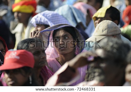 KOLKATA- FEBRUARY 13: An Indian woman listening to the speech and her veil acting as sun protector during a political rally  in Kolkata, India on February 13, 2011.