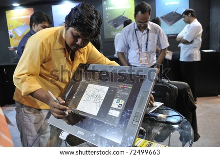 KOLKATA- FEBRUARY 20: A visitor  draws on a screen with a cordless touch pen during the Information and Communication Technology (ICT) conference and exhibition in Kolkata, India on February 20,2011.