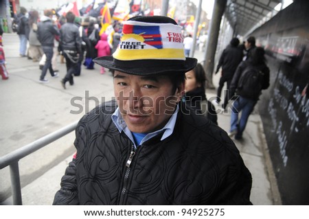 TORONTO - MARCH 10:  A Tibetan man -wearing a Tibetan flag cap participating in a rally organized to protest against the Chinese occupation of Tibet on March 10 2009 in Toronto, Canada.
