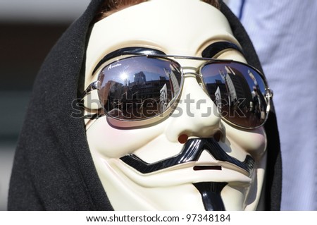 TORONTO - MARCH 11:   A guy with a guy fawkes mask listening to the speakers  during  a  protest against an election fraud from last year\'Â?Â?s federal election on March 11 2012 in Toronto, Canada.