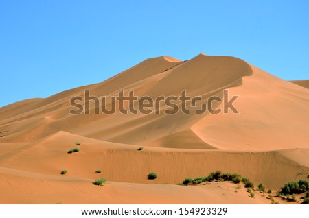 PIQAN, CHINA  SEPTEMBER 4: Kumtag Desert on September 4, 2013 in Piqan, China. Kumtag desert is the only desert linking with city in the world.