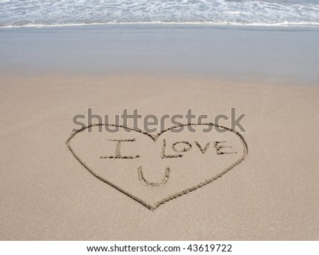 love heart symbol in sand on tropical beach with words i love u and blue water