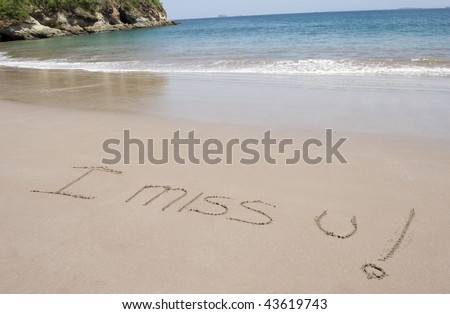 i miss u written in sand on costa rican  tropical beach near blue water