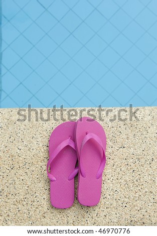 pink shoes on edge of swimming pool with blue water