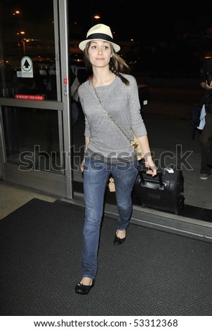 LOS ANGELES , FEBRUARY 4: Actress Emmy Rossum is seen making her way thru LAX (Los ANgeles Airport) carrying her luggage February 4, 2010 in los angeles, california