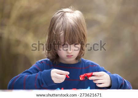 Boy Putting Together his Assembling Toys Outdoors