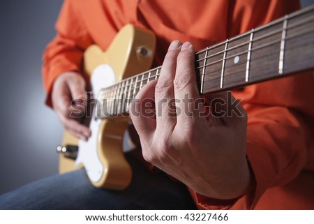 closeup of hands of a musician playing electric guitar