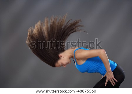 woman with long brown hair shaking her head to make it fly