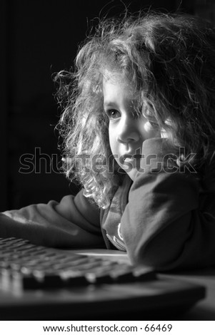 girl playing at the computer in natural light from the window
