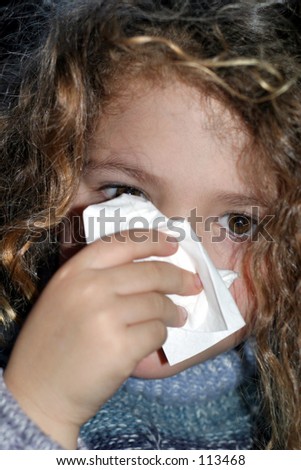 sick child blowing her nose