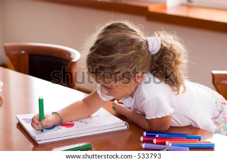 little girl drawing on the table