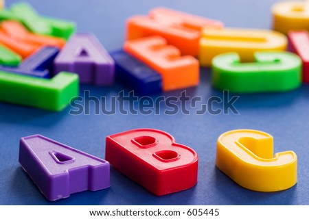 plastic colored letters in diagonal with others out of focus in the background